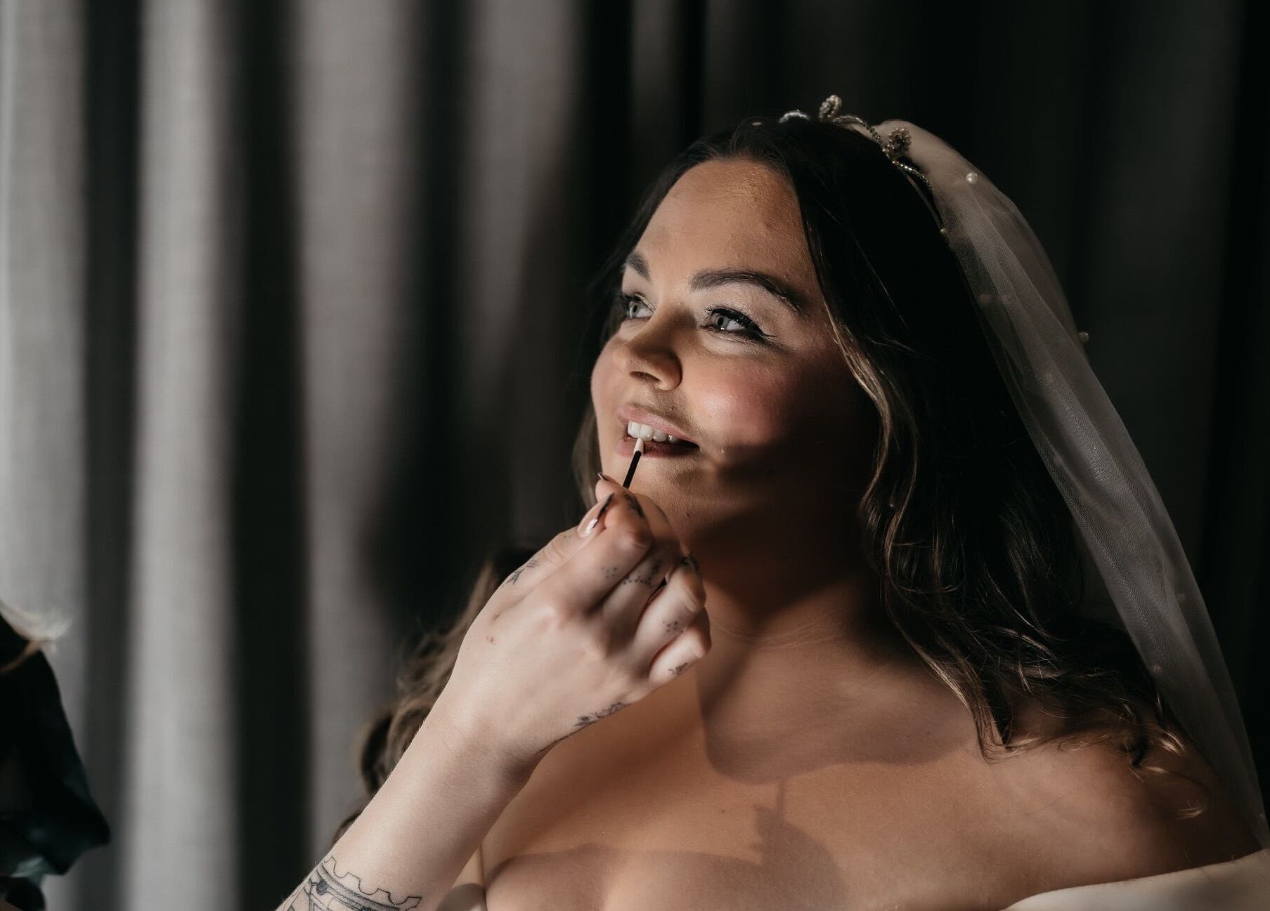 Bride getting makeup by Heather Connor at Elevate, Linlithgow, Scotland, GB. A moment of joyful preparation.