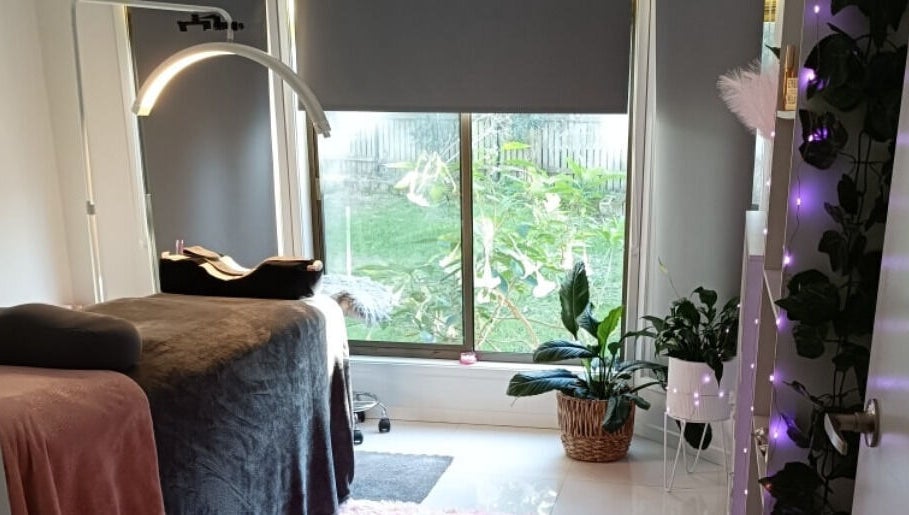 Tranquil interior of Lash Artistry by RK, Buttaba, New South Wales, featuring a treatment bed and green plants.