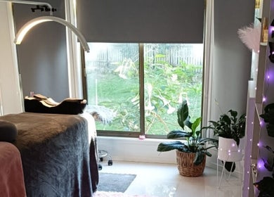 Tranquil interior of Lash Artistry by RK, Buttaba, New South Wales, featuring a treatment bed and green plants.