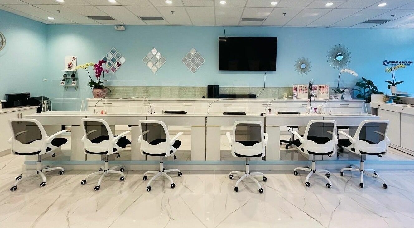 Modern nail service area at Primp and Polish Beauty Salon, Victoria, British Columbia, CA, with sleek white chairs.