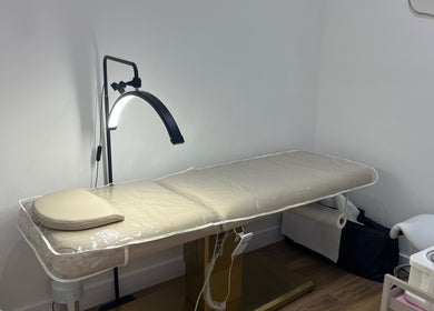 Relaxing treatment room at Nav’s Beauty, London, England, GB, with a comfortable massage table and warm lighting.