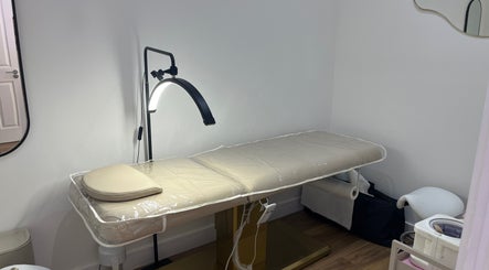 Relaxing treatment room at Nav’s Beauty, London, England, GB, with a comfortable massage table and warm lighting.