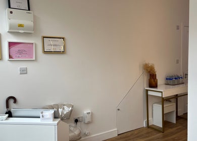 Elegant corner showcasing Nav’s Beauty certificates in London, England, GB with decor and refreshments.