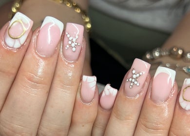 Elegant pink acrylic nails with embellishments at Pops Beauty Studio in Gwent, Wales, GB.