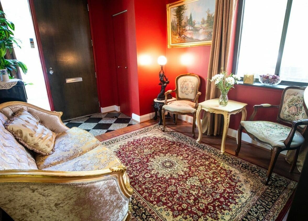 Luxurious seating area at SYL Spa, North Bethesda, Maryland, US with vintage decor and vibrant red walls.