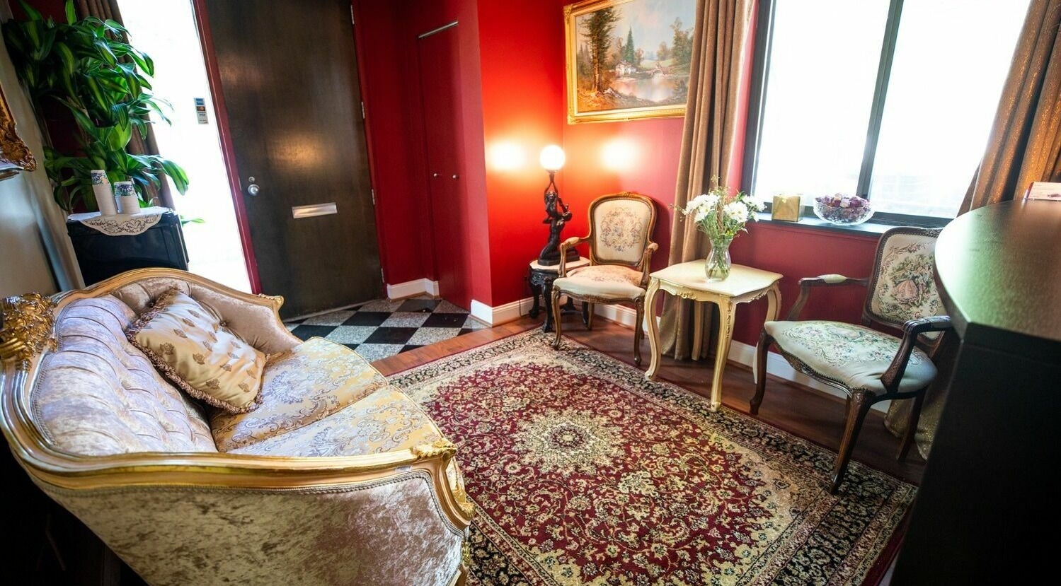 Luxurious seating area at SYL Spa, North Bethesda, Maryland, US with vintage decor and vibrant red walls.