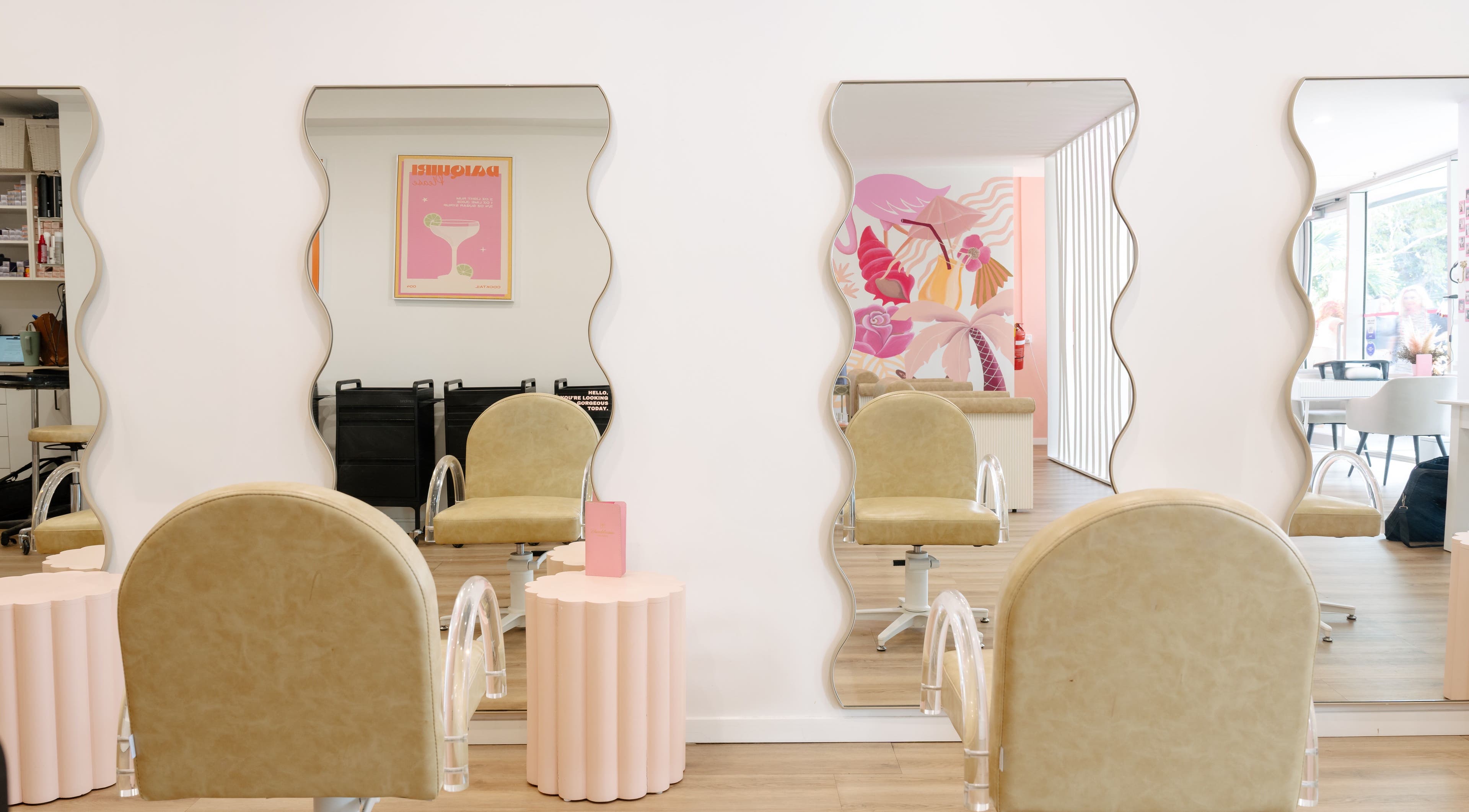 Wave mirrors and chic salon chairs at Blondelicious in Palm Cove, Queensland, AU create a stylish aesthetic.