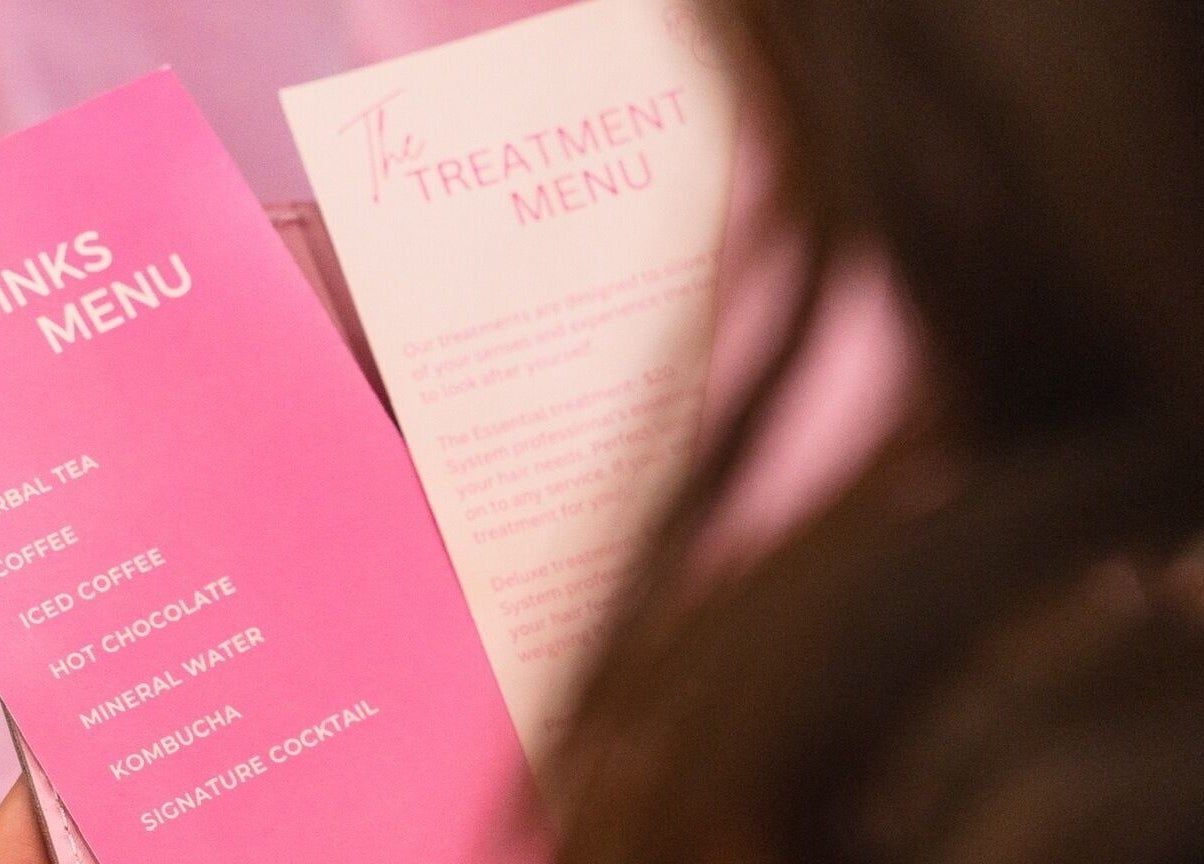 Blondelicious menu in Palm Cove, Queensland, AU showcasing drinks and treatments in a pink setting.