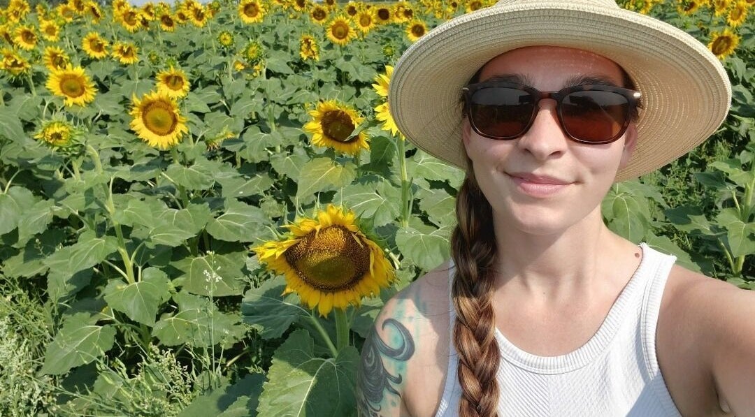 Woman in sunflower field near Restorative Health Massage, Fargo, North Dakota, US.
