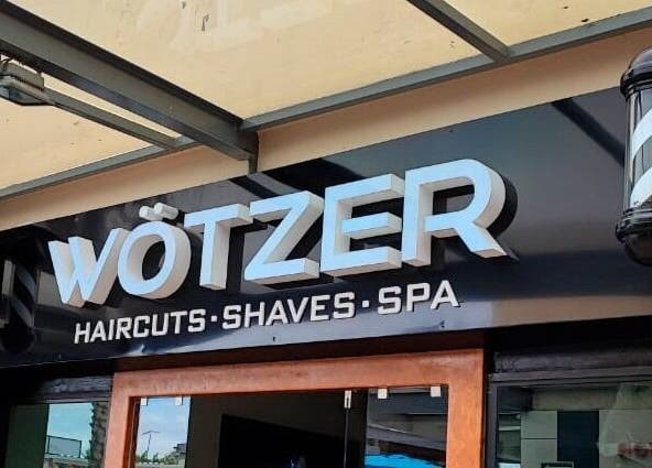 Entrada de Wötzer Barbería & Spa en Juriquilla, Querétaro, MX con letrero iluminado.