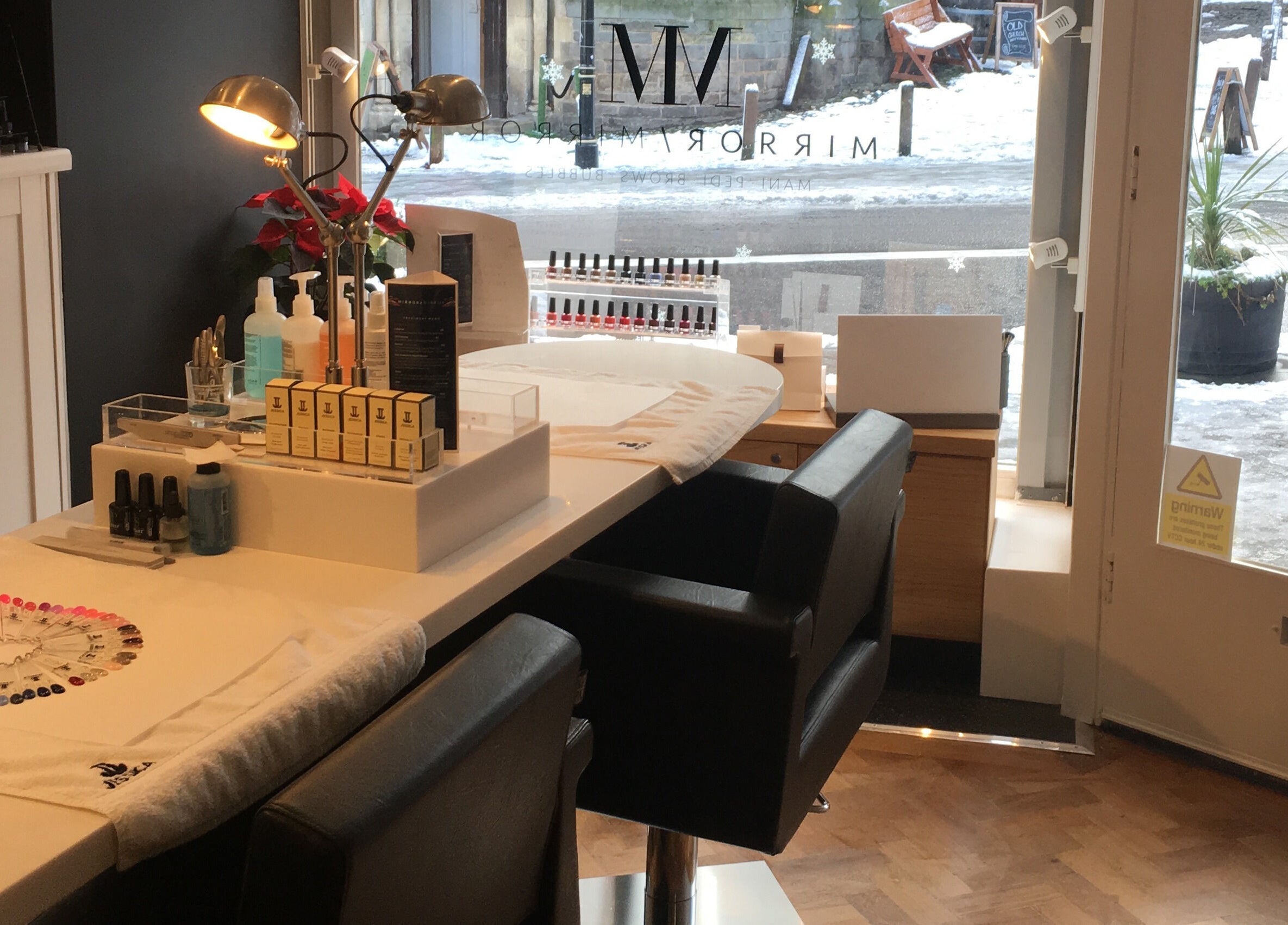 Modern beauty station at Mirror Mirror Shrewsbury, Shrewsbury, GB, featuring nail polish and sleek seating.