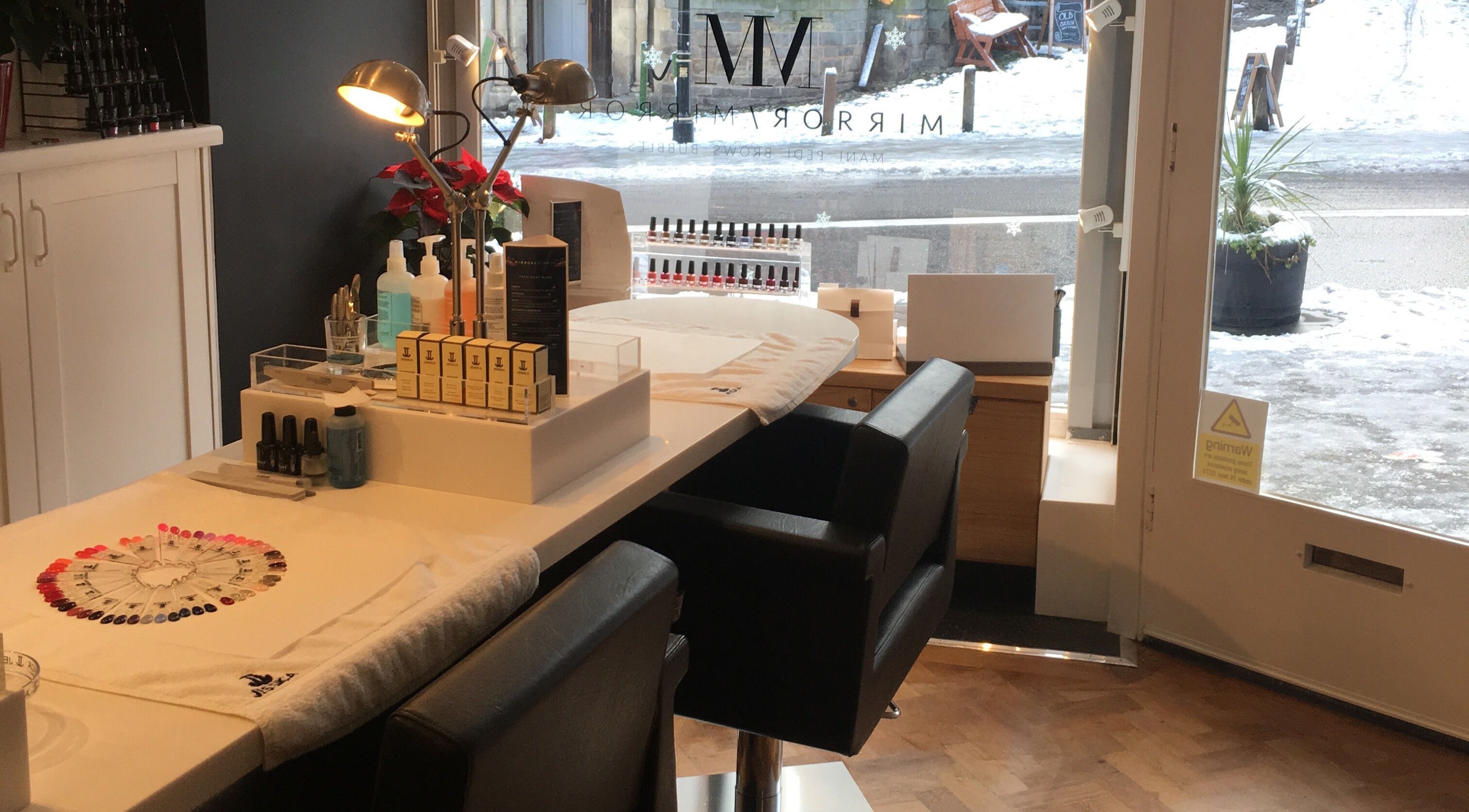 Modern beauty station at Mirror Mirror Shrewsbury, Shrewsbury, GB, featuring nail polish and sleek seating.