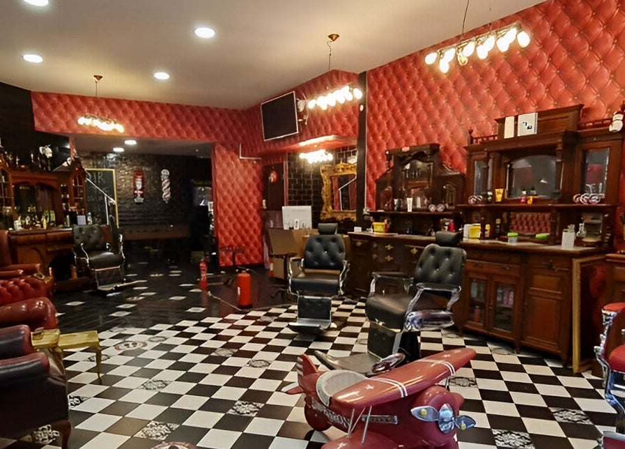 Chic vintage interior of Brazuca B5 Barbers in Carlisle, England, GB, featuring plush chairs and classic decor.