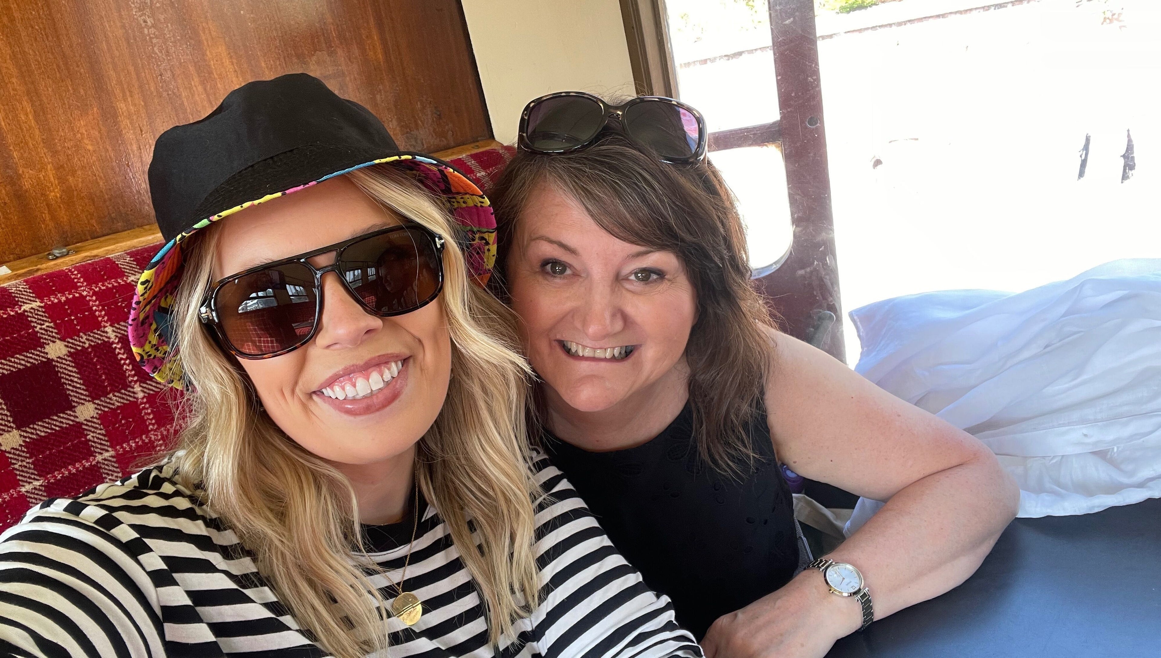 Two smiling women enjoying a comfortable setting at Number 8 Barbers, Brechin, Scotland, GB.