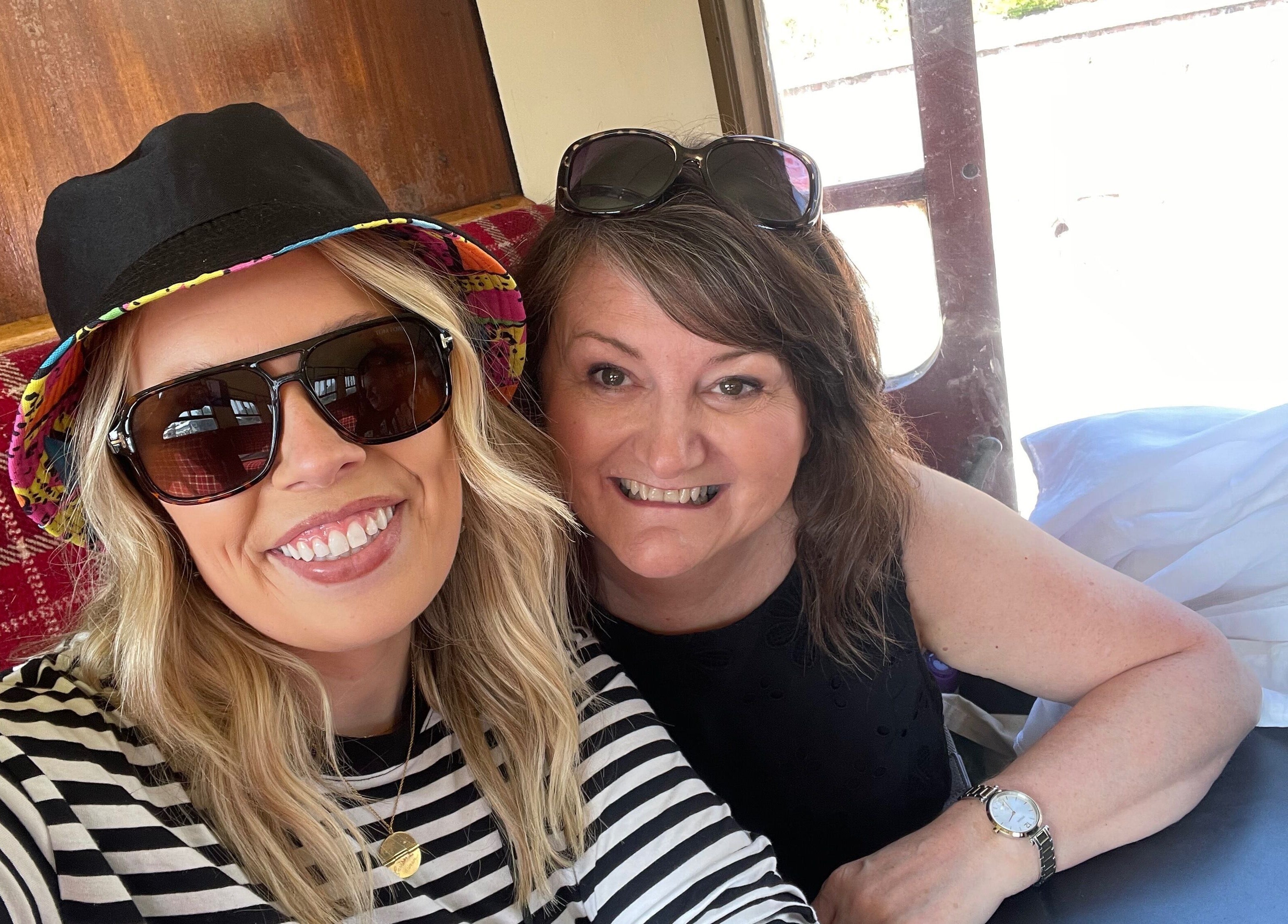Two smiling women enjoying a comfortable setting at Number 8 Barbers, Brechin, Scotland, GB.