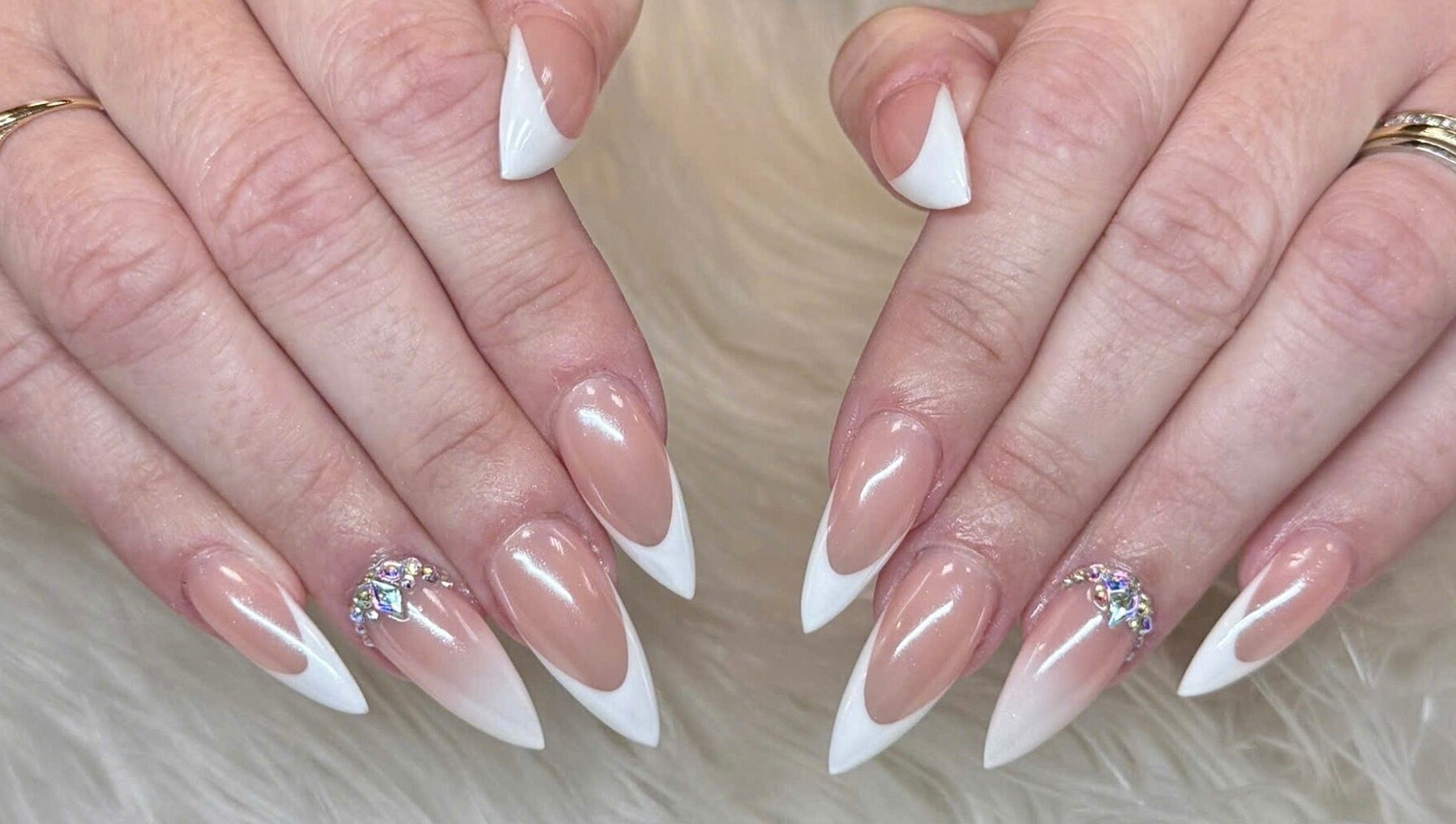 Elegant French tip nails with gems at Beauticure Nails, Toronto, Ontario, CA showcasing chic style.