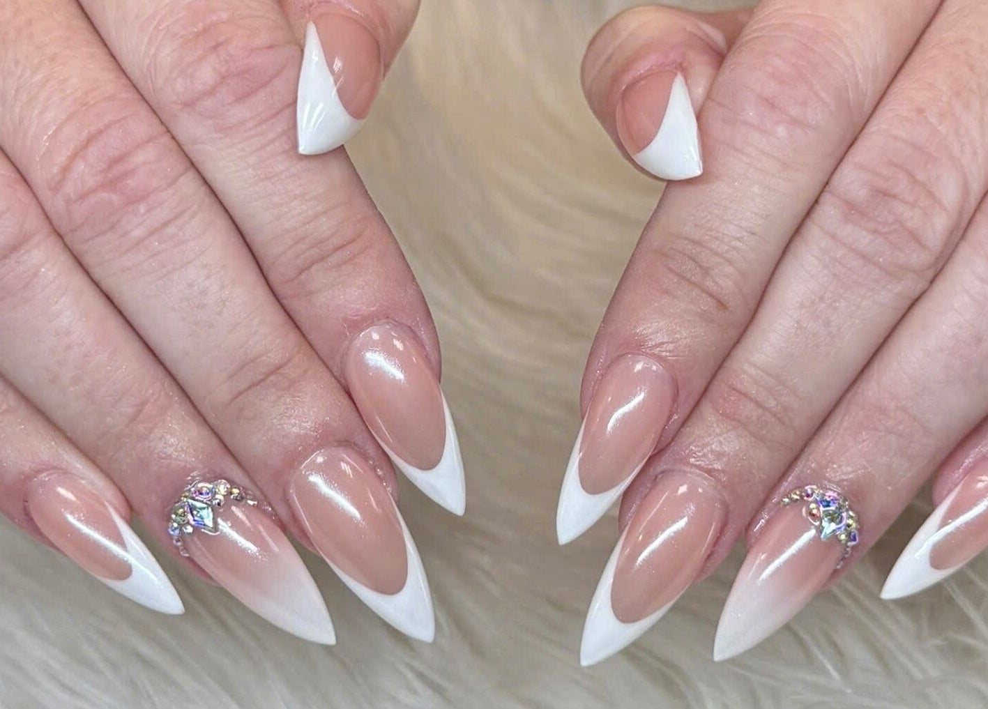 Elegant French tip nails with gems at Beauticure Nails, Toronto, Ontario, CA showcasing chic style.