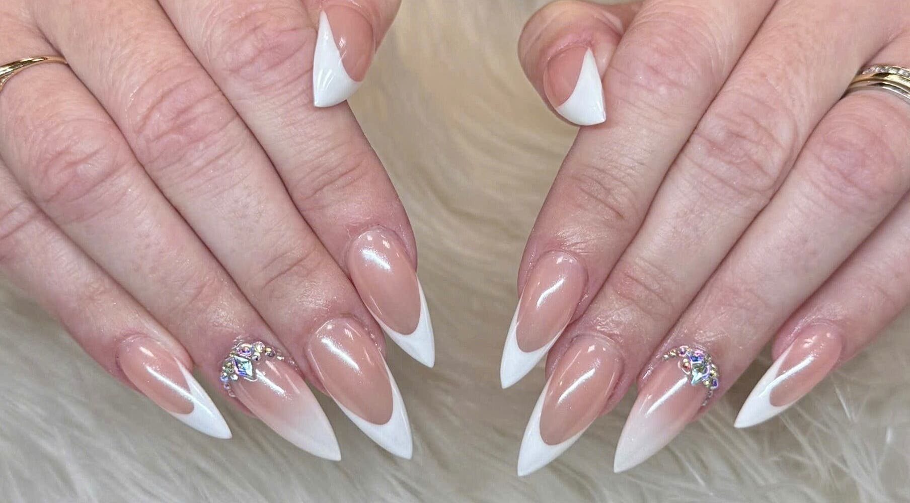 Elegant French tip nails with gems at Beauticure Nails, Toronto, Ontario, CA showcasing chic style.