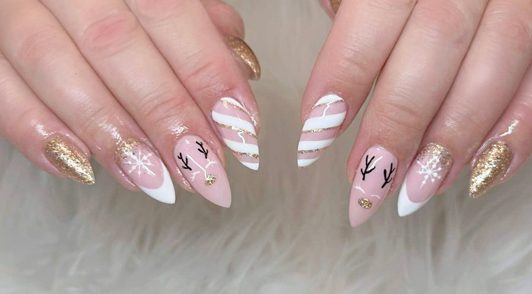 Festive nail art with gold glitter and white patterns at Beauticure Nails, Toronto, Ontario, CA.
