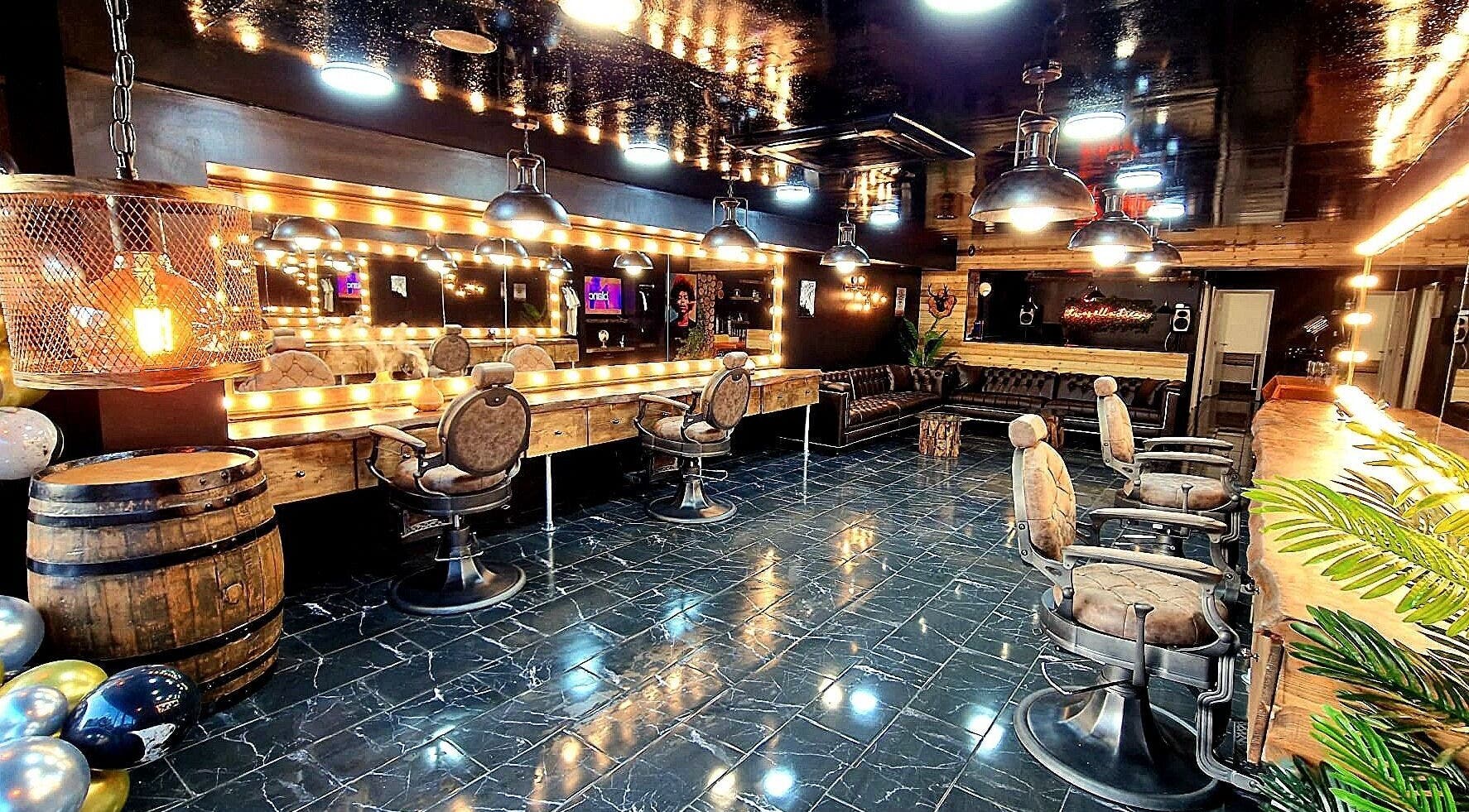 Elegant interior of Fade Masters Barbers & Tanning Salon Hale, Hale Barns, England, featuring stylish chairs and mirrors.