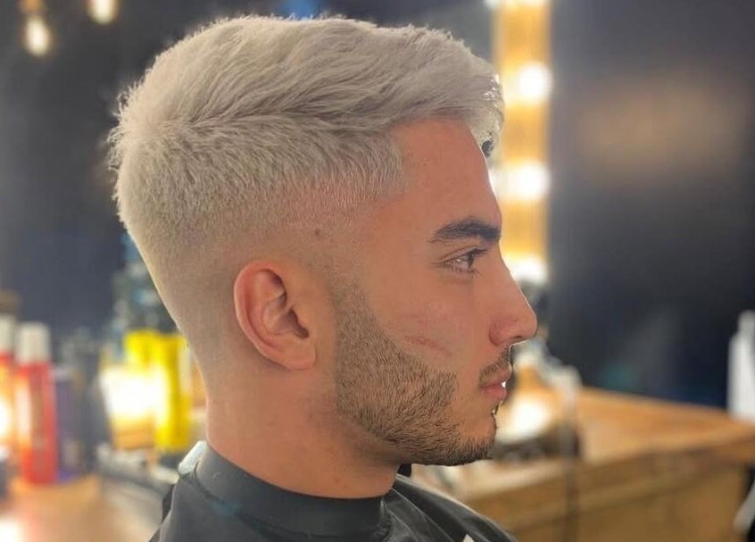 Stylish haircut at Fade Masters Barbers & Tanning Salon Hale in Hale Barns, England, GB with well-lit mirrors.