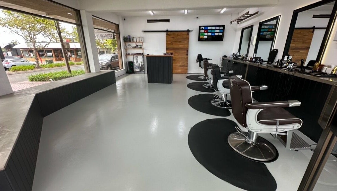 Modern interior of Barber Theory, Nowra, New South Wales, AU, featuring sleek styling chairs and large windows.