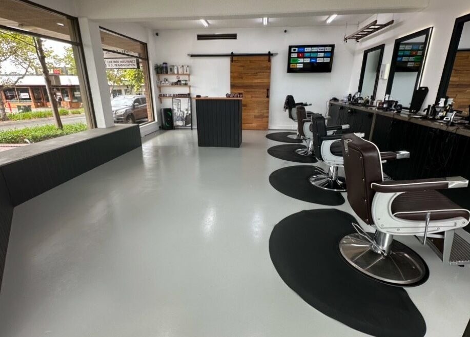Modern interior of Barber Theory, Nowra, New South Wales, AU, featuring sleek styling chairs and large windows.