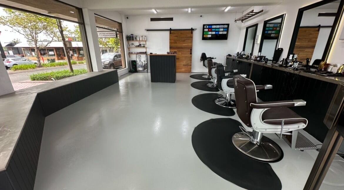 Modern interior of Barber Theory, Nowra, New South Wales, AU, featuring sleek styling chairs and large windows.