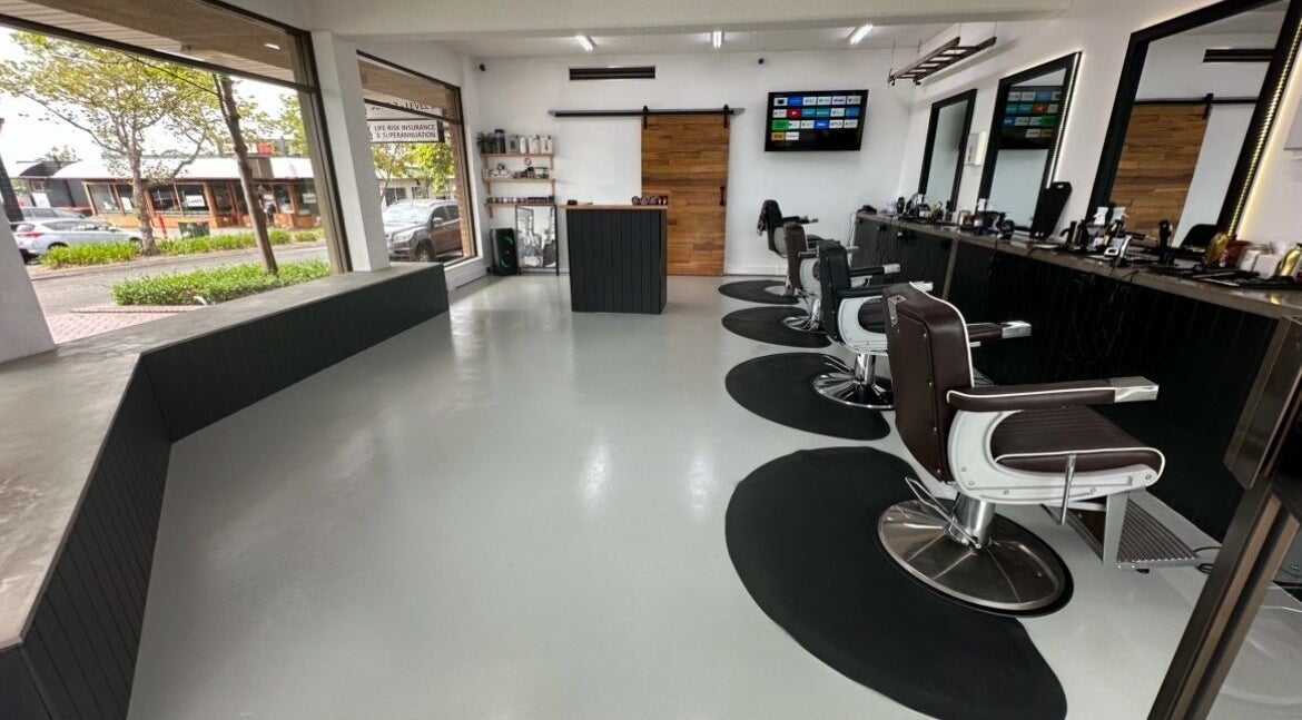 Modern interior of Barber Theory, Nowra, New South Wales, AU, featuring sleek styling chairs and large windows.