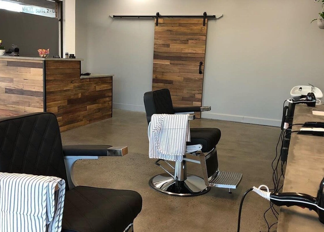 Modern interior of Barber Theory in Nowra, New South Wales, AU showcasing sleek barber chairs and rustic decor.