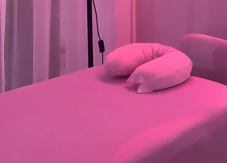 Relaxing massage bed at Lash and Dash, Sandton, Gauteng, ZA, illuminated by soothing pink light.