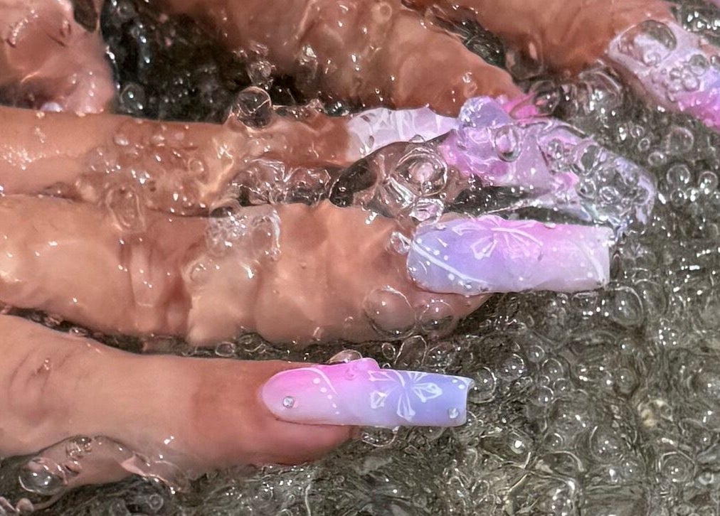 Colorful nails submerged in water at Funkd Up Nails, Montréal, Québec, CA showcasing vibrant nail art.