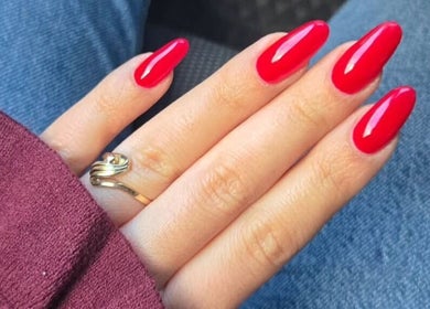 Red manicured nails at Nails by Natasha, Dorval, Quebec, CA showcasing stunning nail art.