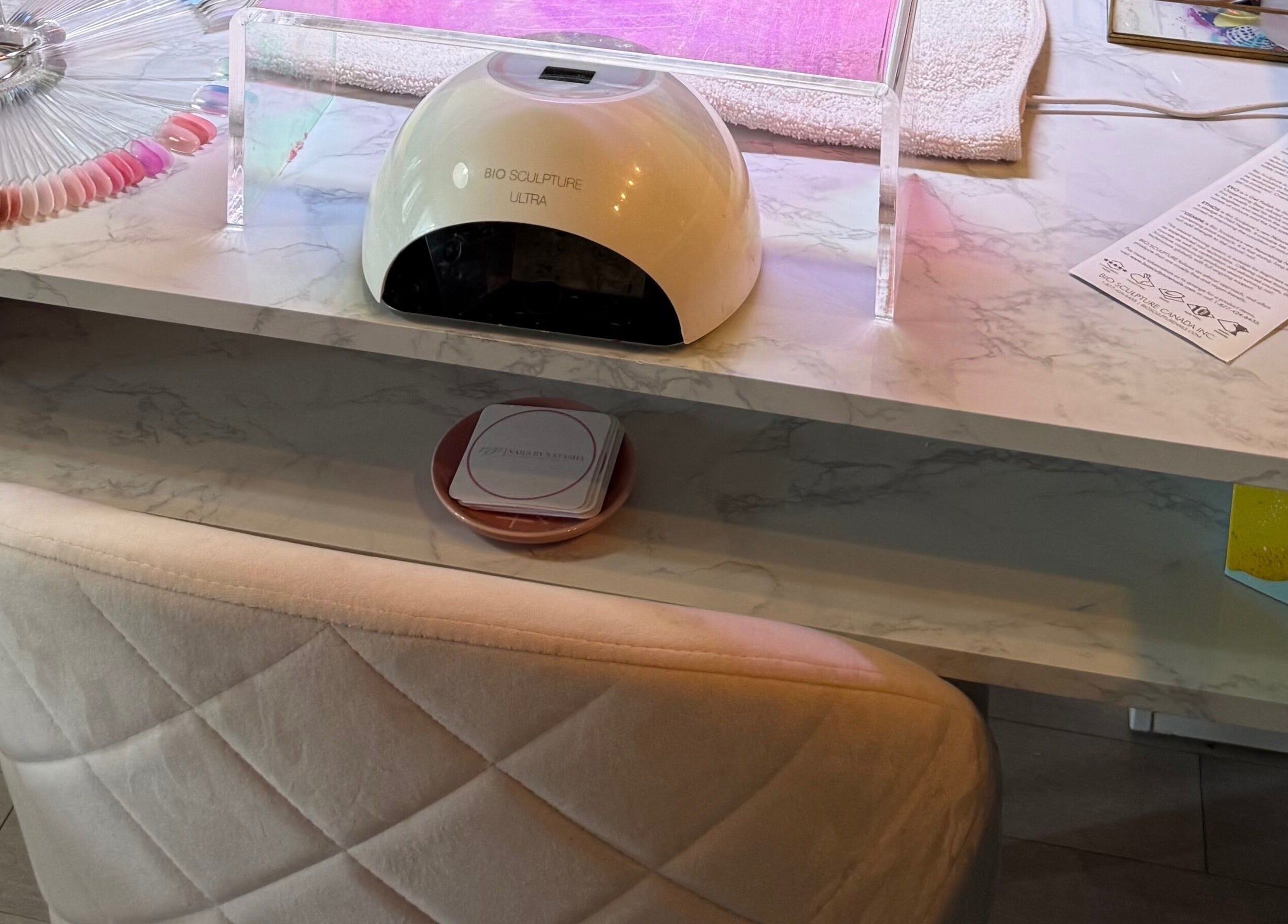 Elegant nail station at Nails By Natasha in Dorval, Quebec, CA featuring a gel dryer and color palette.