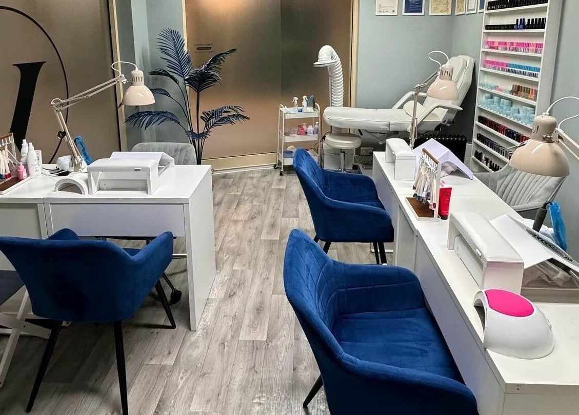 Interior of Vyrsta Studio nail salon in London, England, GB with blue chairs and manicure stations.