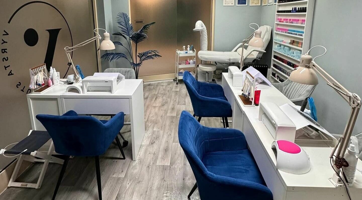 Interior of Vyrsta Studio nail salon in London, England, GB with blue chairs and manicure stations.