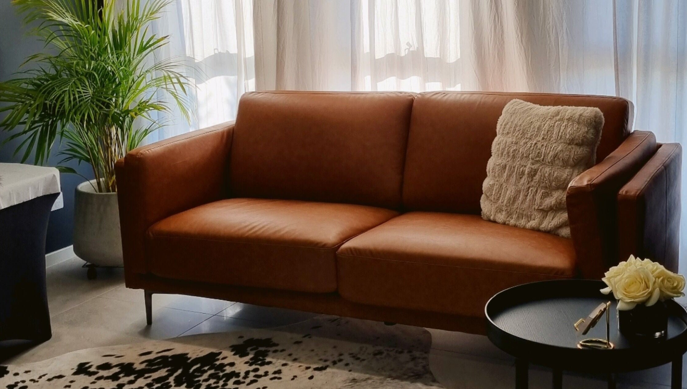 Inviting lounge area at Beauty Therapeutics, Oran Park, New South Wales, AU with brown sofa and decor.