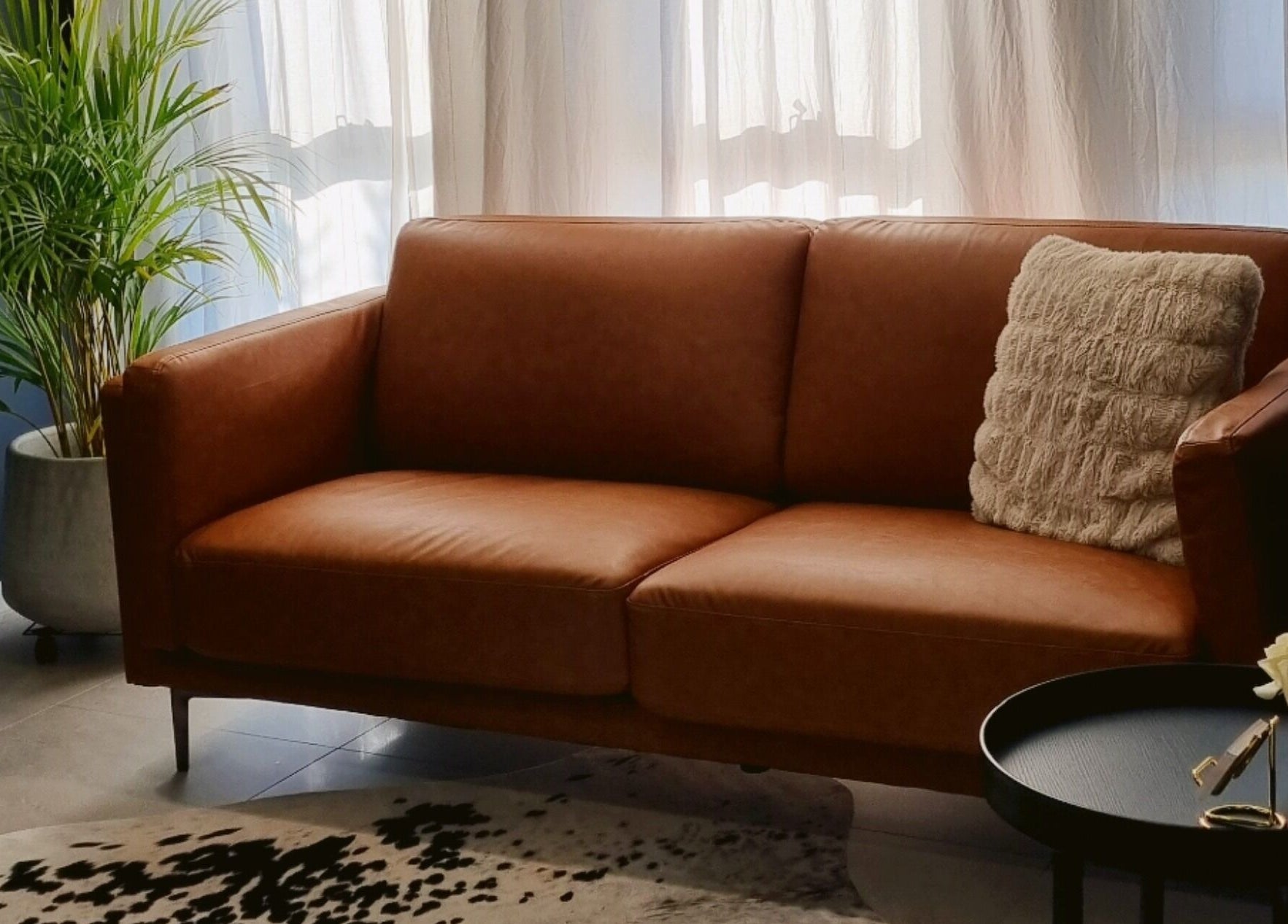 Inviting lounge area at Beauty Therapeutics, Oran Park, New South Wales, AU with brown sofa and decor.
