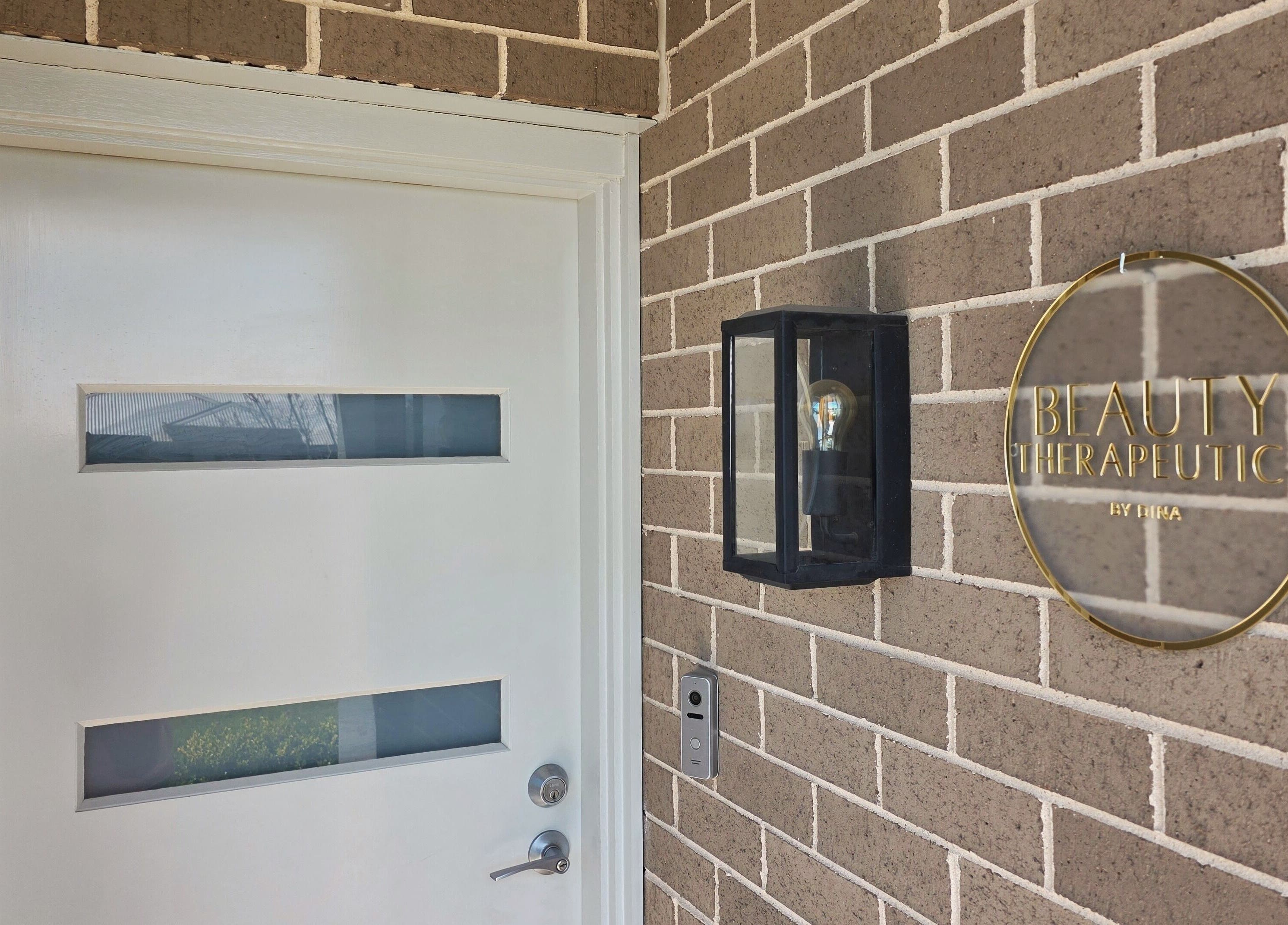 Entrance of Beauty Therapeutics in Oran Park, New South Wales, AU, featuring modern signage and a stylish light fixture.