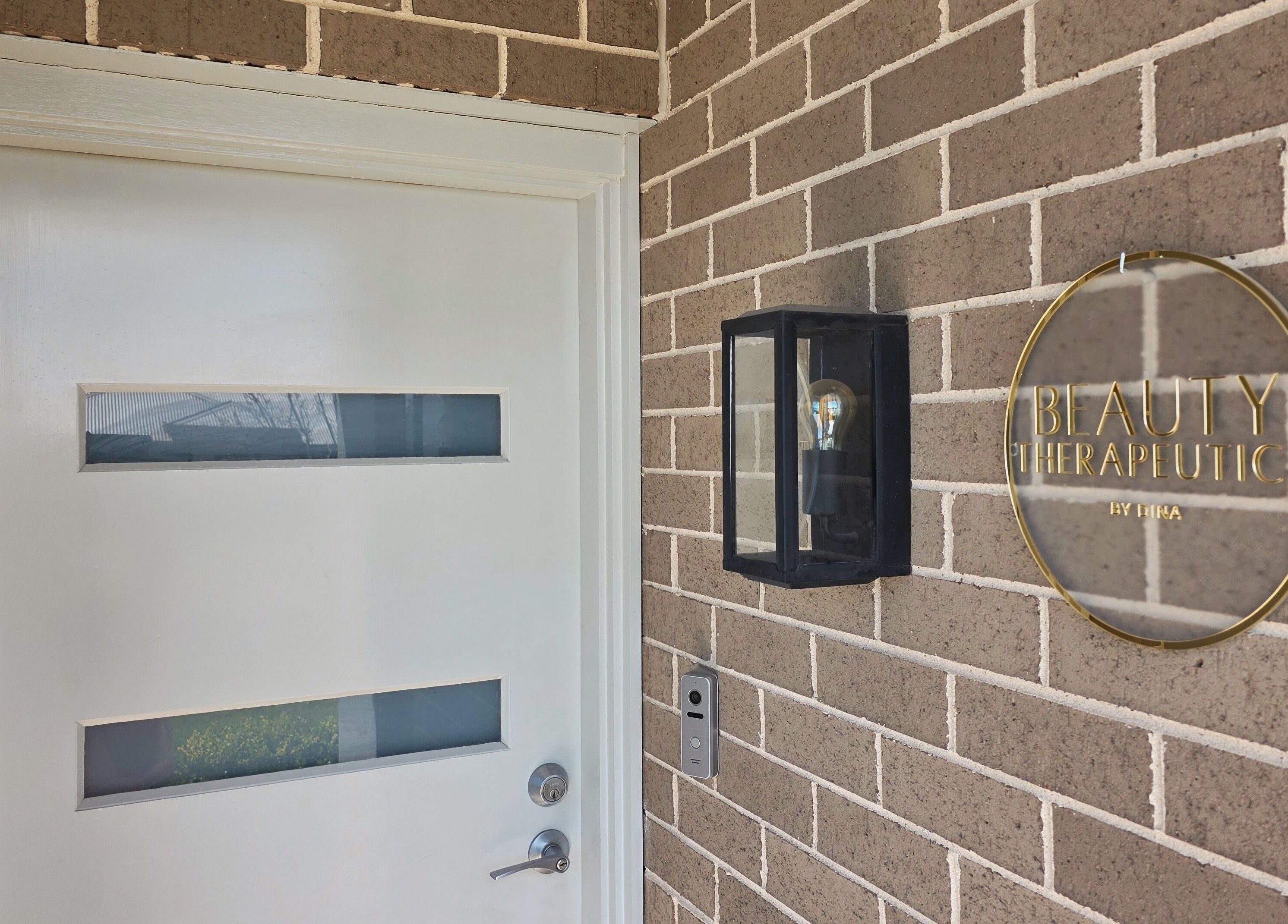Entrance of Beauty Therapeutics in Oran Park, New South Wales, AU, featuring modern signage and a stylish light fixture.