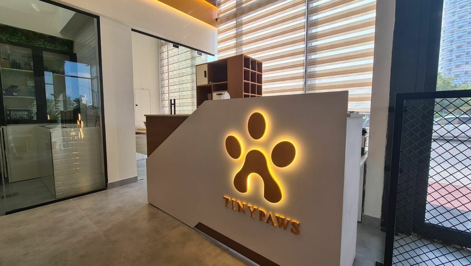 Reception area of Tiny Paws, Dubai, AE featuring an illuminated paw logo and modern decor.