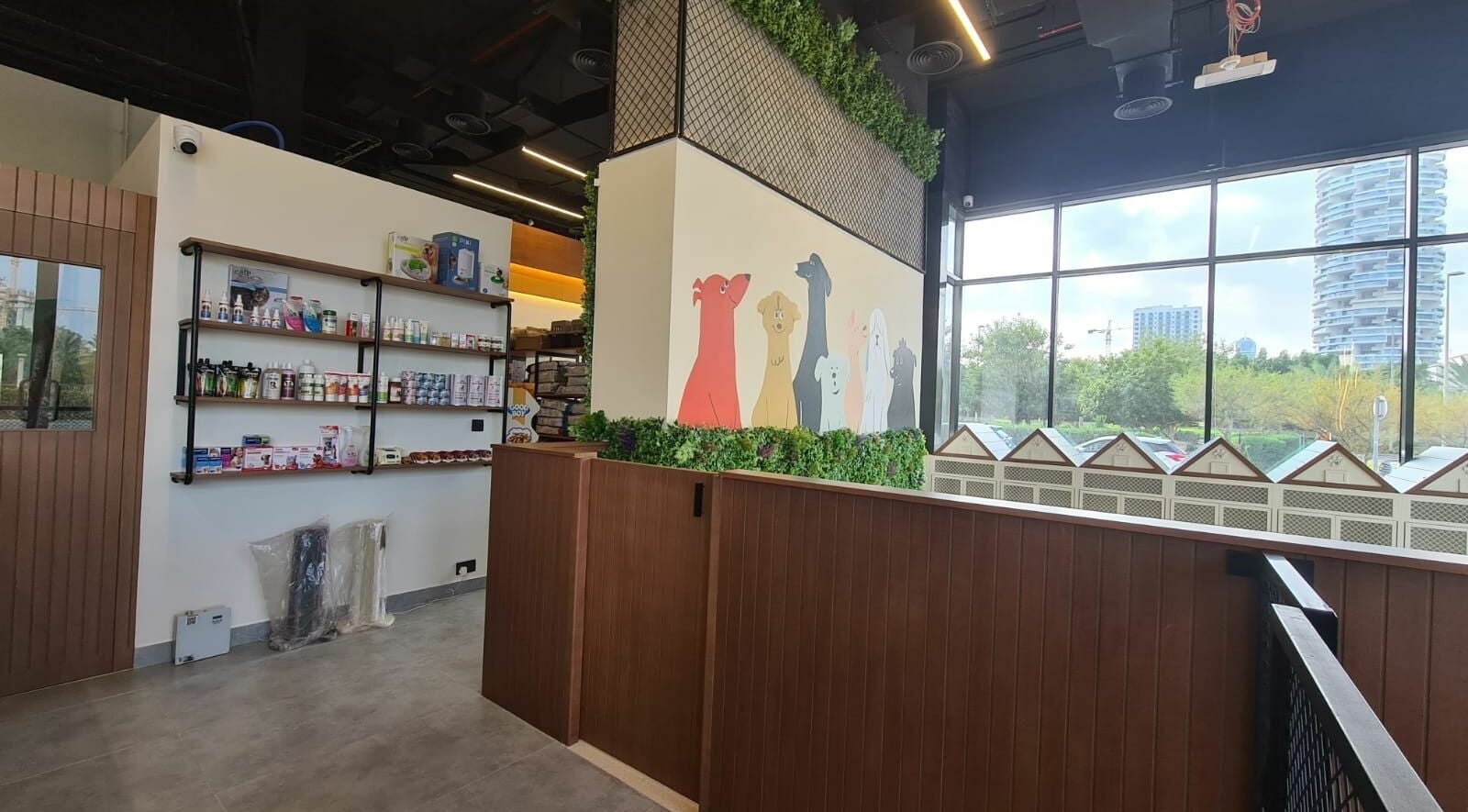Modern pet supply wall inside Tiny Paws venue in Dubai, AE, featuring vibrant dog illustrations and greenery.