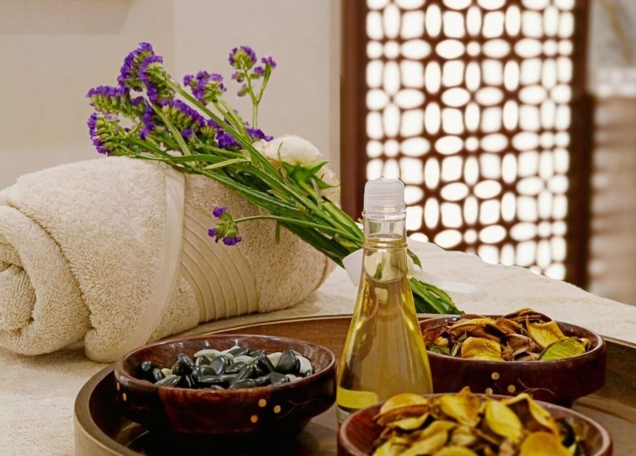 Relaxing spa setup with oils and fresh flowers at Healing Zone Spa, Sharjah, AE.