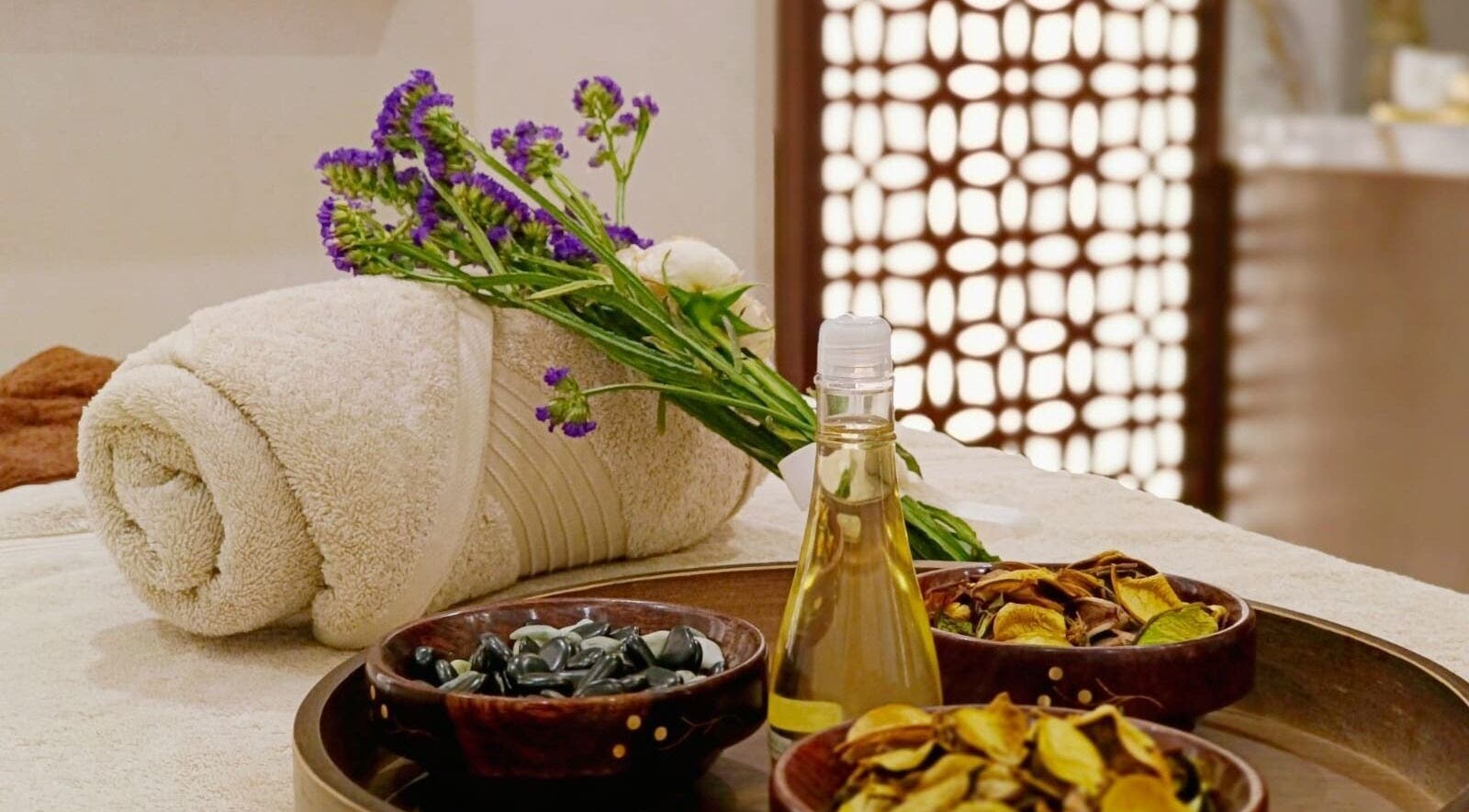 Relaxing spa setup with oils and fresh flowers at Healing Zone Spa, Sharjah, AE.