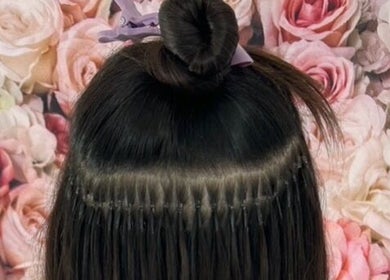 Hair extensions styled at Popellas Hair & Extensions, Bournemouth, England, GB, against a floral backdrop.