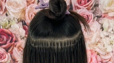 Hair extensions styled at Popellas Hair & Extensions, Bournemouth, England, GB, against a floral backdrop.