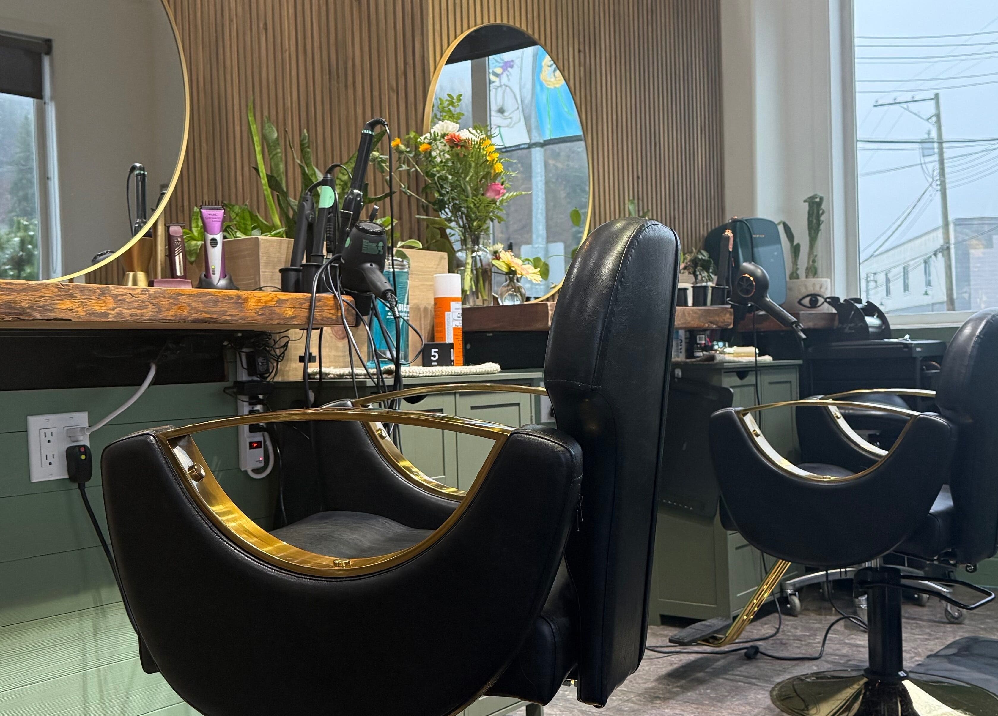 Elegant salon stations at The Collective Beauty Company, Revelstoke, BC, CA with black chairs and mirrors.
