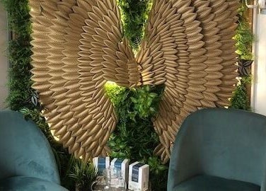 Elegant seating with golden wing decor at Zen Botanica, Barry, Wales, GB.