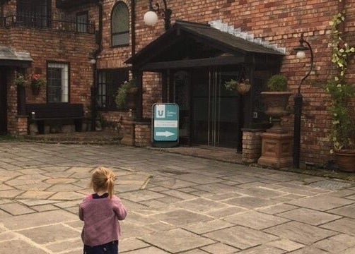 Charming entrance of Zen Botanica in Barry, Wales, GB with brickwork and potted plants.