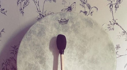 Buffalo drum at Anna Casey Holistic Bodywork, Newcastle upon Tyne, England, GB, against a floral wallpaper backdrop.